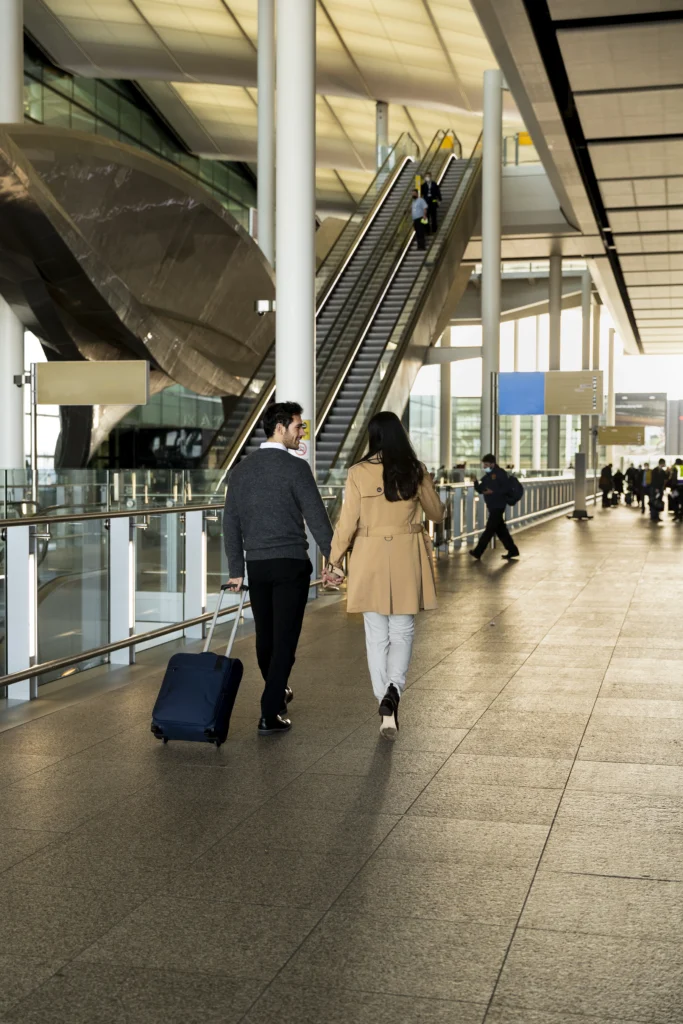 full shot couple holding hands airport